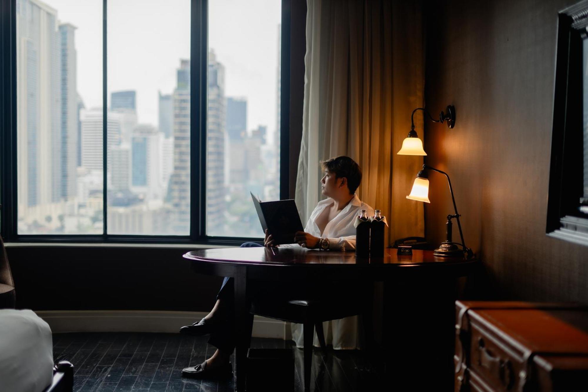 Hotel Muse Bangkok, Autograph Collection Exteriér fotografie A man working in a hotel room