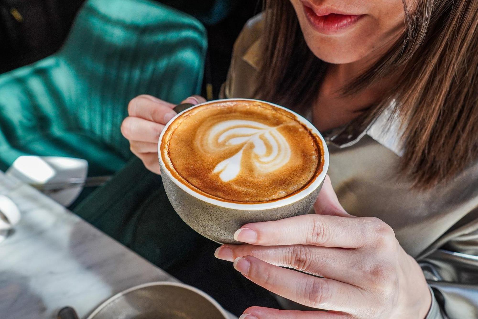 Hotel Muse Bangkok, Autograph Collection Exteriér fotografie A woman holding a cup of coffee